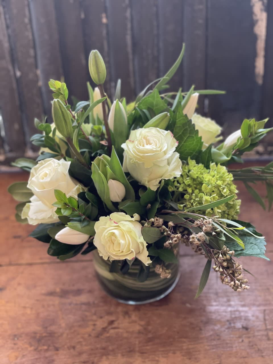 Green and White Sympathy Designers Choice - An arrangement of premium green and white blooms are arranged low and lush to create a sympathetic condolence bouquet.