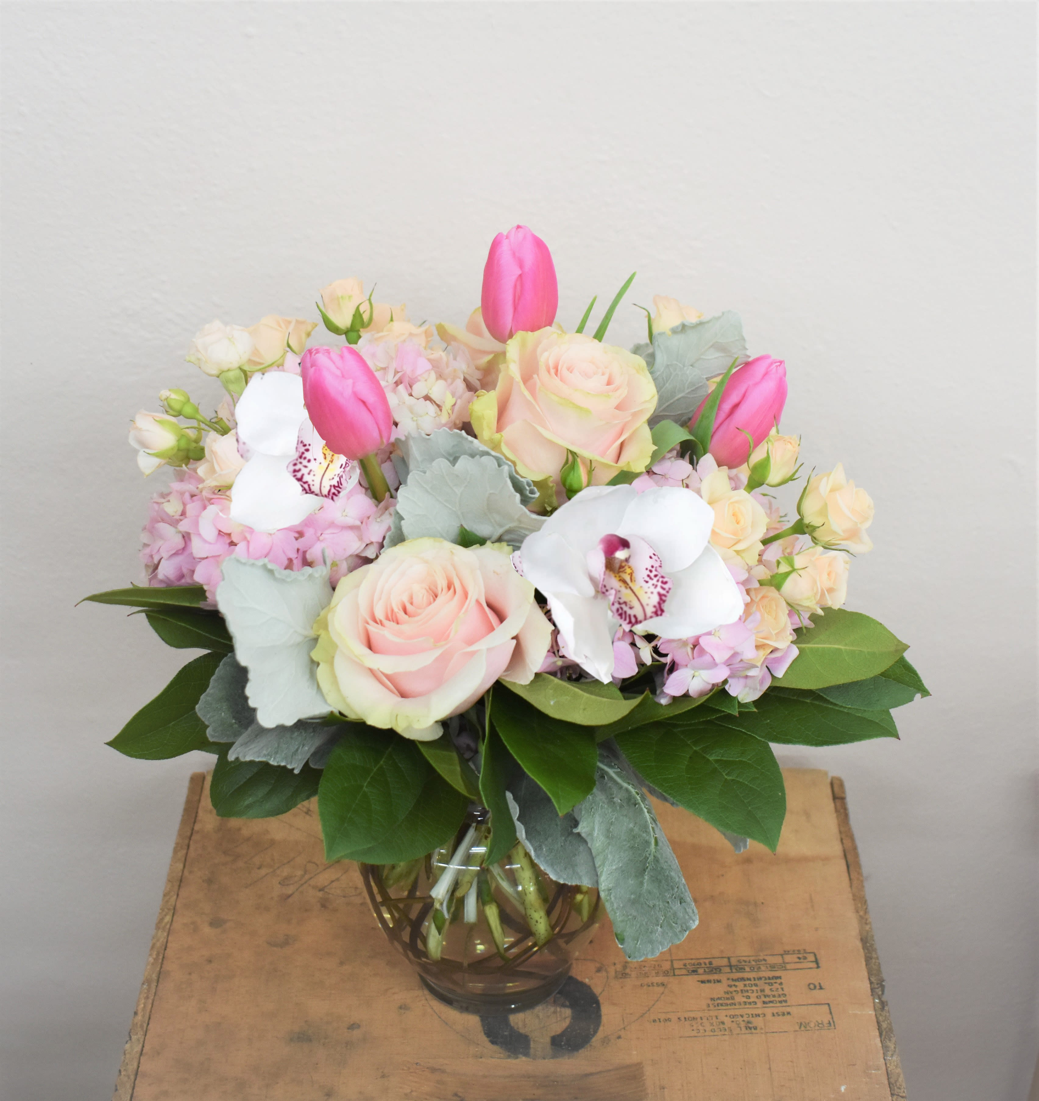 Once Upon A Dream - Soft, romantic, and dreamy describes this gorgeous bouquet! Soft pink Hydrangea, blush roses, peach spray roses, pink tulips, dusty miller and lush greens are designed in a clear vase and accented by curly willow...the perfect way to celebrate any occasion! 