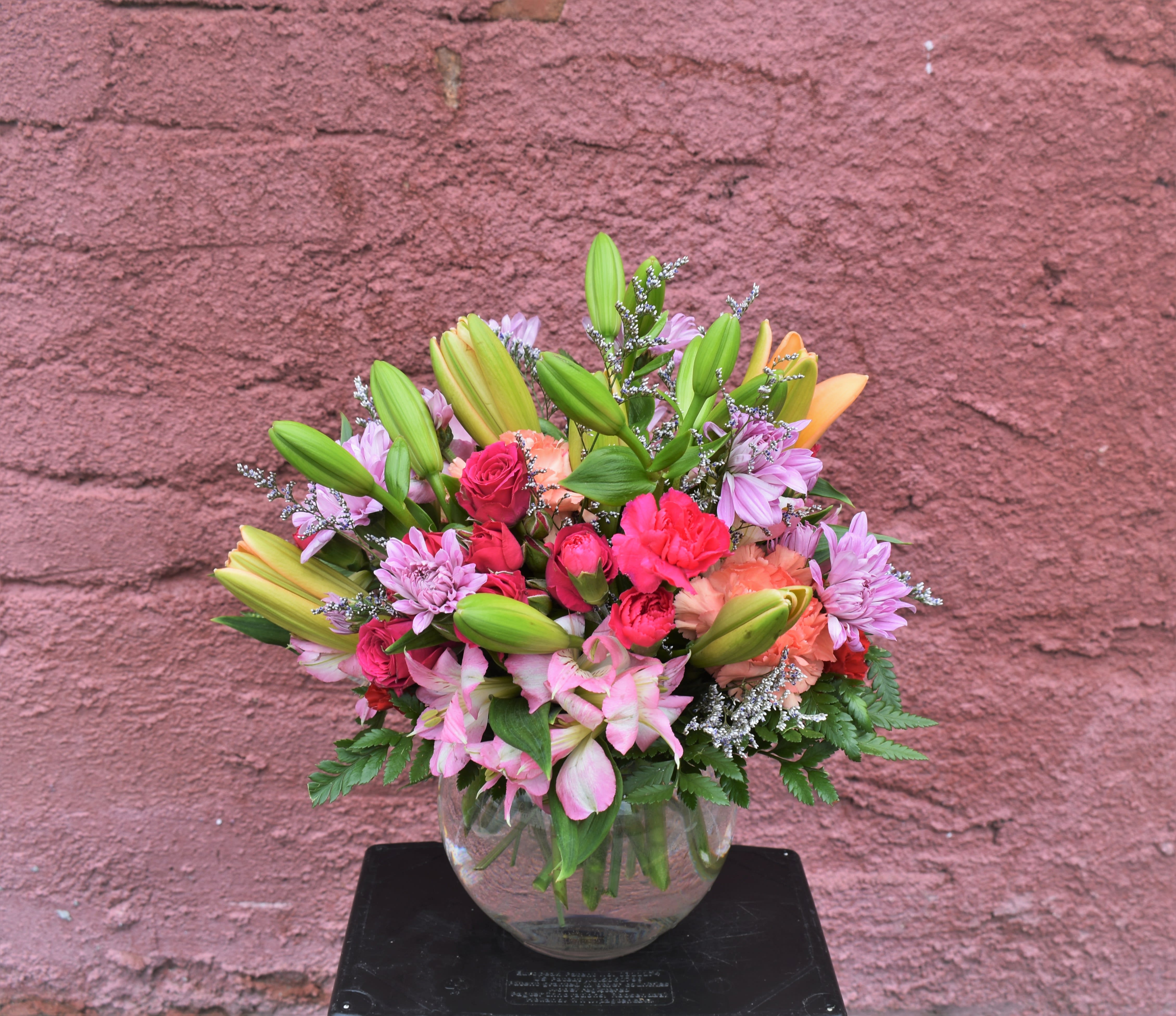 Light Up My Life Bouquet - This Bouquet offers your special recipient fresh vibrant color to brighten their day! Orange Asiatic lilies, fuchsia carnations, pink Peruvian lilies, lavender chrysanthemums and lush greens are perfectly arranged in a clear glass bubble bowl vase to send your sweetest sentiments across the miles. 