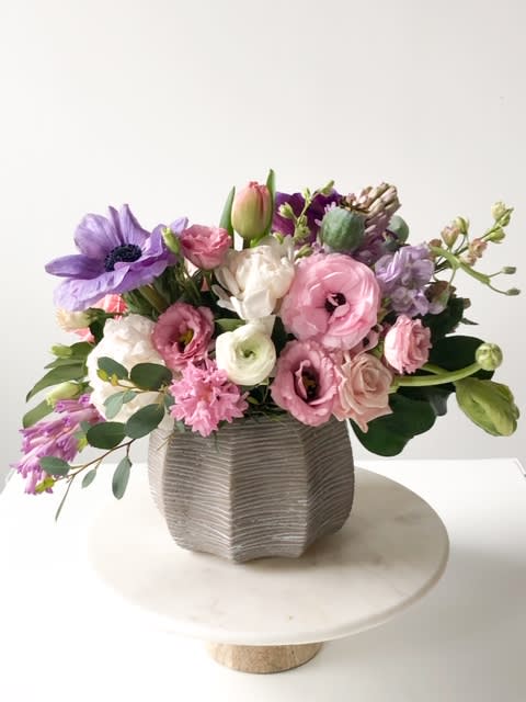 Mother's Garden Mother's Garden - Beautiful display of everything you would find in your Mother's Garden, bursting with ranunculus, peonies, roses, tulips, and hyacinth. These premium blooms offer a fresh fragrance that will add instant happiness to any home.