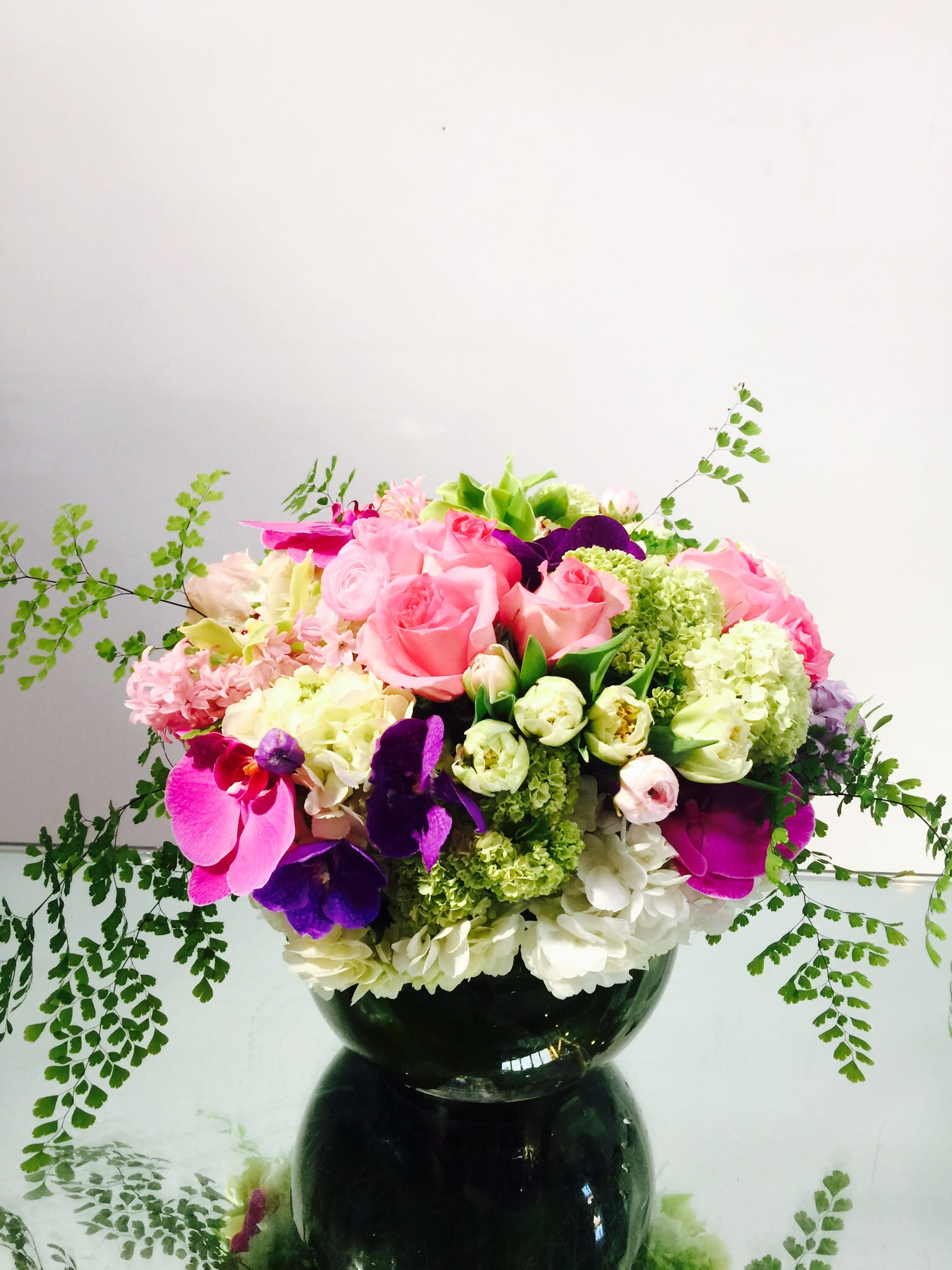 Mother's Day Jubilee Mother's Day Jubilee - Gorgeous arrangement of jewel-toned and pastel blooms - fresh green and white hydrangeas, viburnum, and tulips accented with pink and purple roses and phalaenopsis orchids. A perfect gift for mothers everywhere.