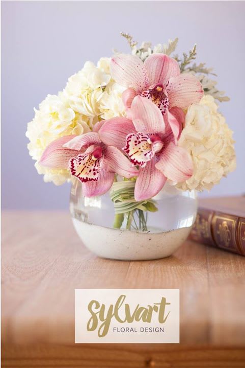 HEAVENLY ORCHID - This lovely combination of Cymbidium Orchid, white Hydrangea, Dusty Miller presented in a round glass vase accented with white sea sand. (Florals and container might vary due to availability.) Note: If you would like to change floral color, please add your request in the note section when placing your order.
