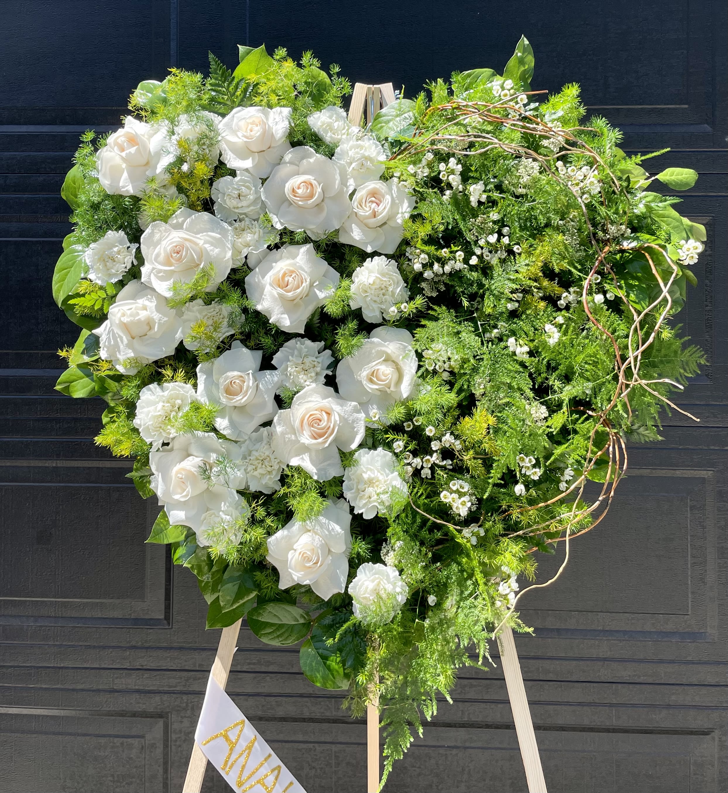 Timeless Heart  - Timeless Heart is designed in a mixture of ivory roses and lush greens with curly willow details. The perfect selection to celebrate your loved one.   Our designs are sure to stand out as each arrangement is carefully created to capture the emotion with flowers. Arrangement comes with aisle and ribbon with your choice of writing. 