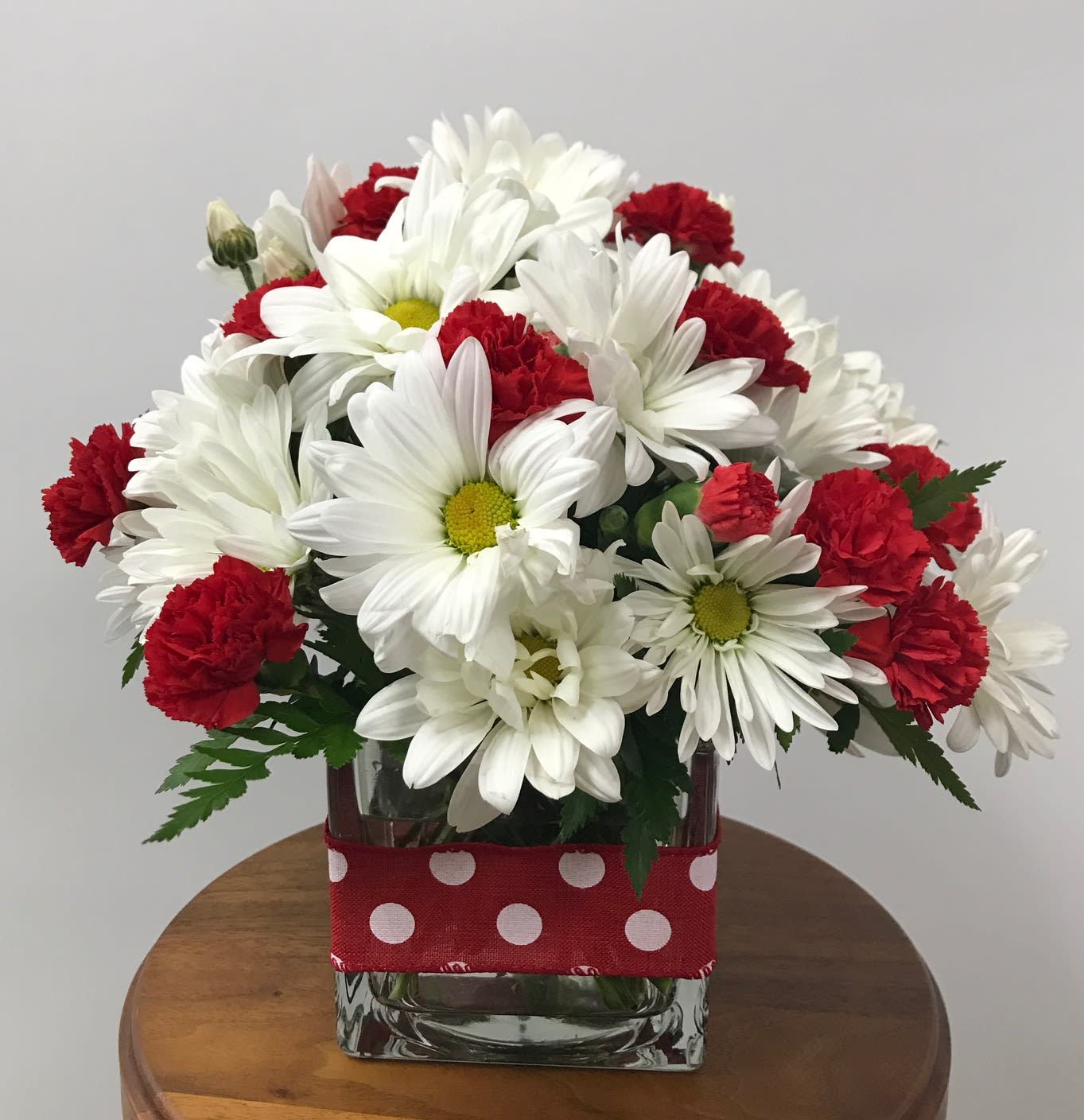  Polka Dots &amp; Posies - Polka dot ribbon wrapped around a clear cube with a bouquet of white daisies and red mini-carnations.  Just the right gift. Also available in pink and white.  