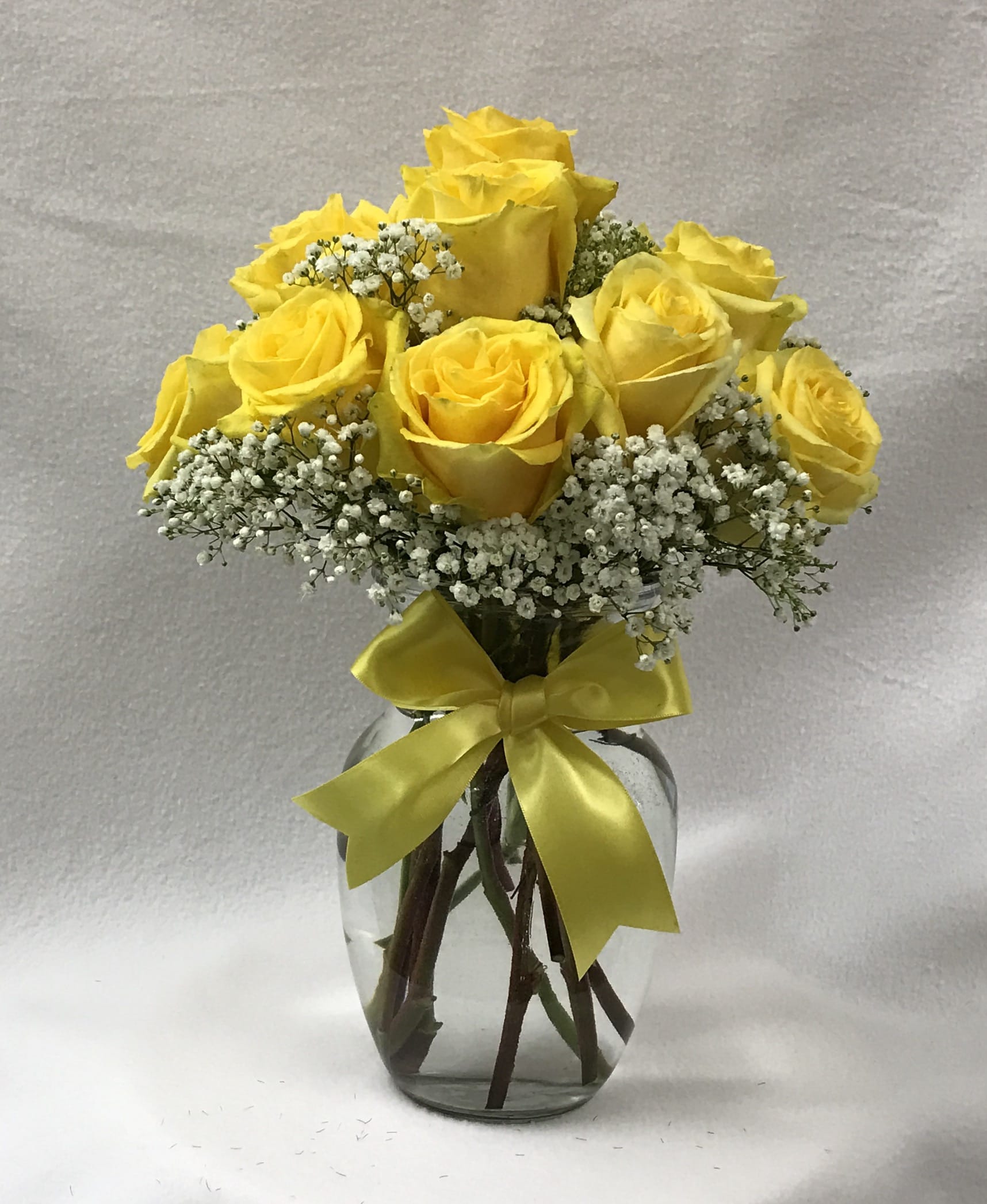 Golden Glow Rose Bouquet - A dozen yellow roses with baby's breath. Deluxe:  18 roses Premium:  24 roses ****YOU MAY ALSO PURCHASE THIS BOUQUET IN COLORS OTHER THAN RED, CALL US FOR COLOR AVAILABILITY.