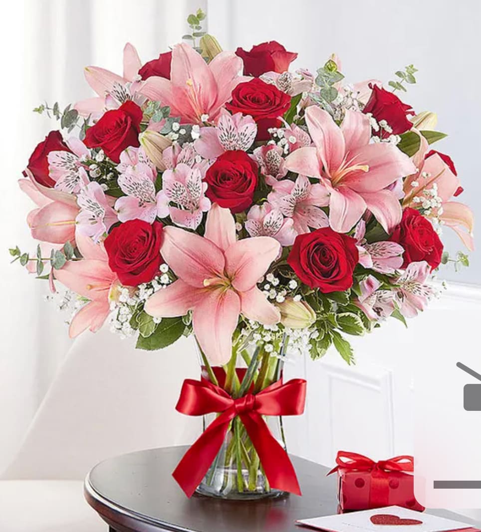 Lovely Lovely - All-around arrangement with red roses; pink Asiatic lilies and Peruvian lilies (alstroemeria); accented with baby’s breath, spiral eucalyptus and assorted greenery
