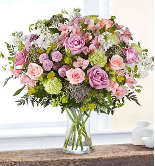 Charming Garden - With a charm and beauty all its own, our garden-inspired bouquet brightens every day. A loose gathering of pastel blooms creates a fresh-picked look, complete with lush touches of greenery. Hand-designed inside a clear glass vase, it’s a gift that delivers your sentiments in the most delightful way.