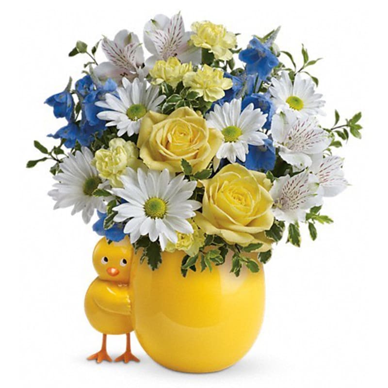 Teleflora's Sweet Peep Bouquet - Baby Blue - A little one has arrived! Welcome them home with a lush bouquet of yellow roses and blue delphinium, beautifully arranged in this adorably cheerful chicky vase. The new parents will love to display the sweet ceramic keepsake in the nursery!  Surprise them with this bouquet of stunning yellow roses, white alstroemeria, miniature light yellow carnations, light blue delphinium, white daisy spray chrysanthemums, pitta negra and lemon leaf. Delivered in a Happy Chick keepsake.      Orientation: One-Sided      All prices in USD ($)      Standard      TNB04-1A      Deluxe      TNB04-1B      Premium      TNB04-1C 