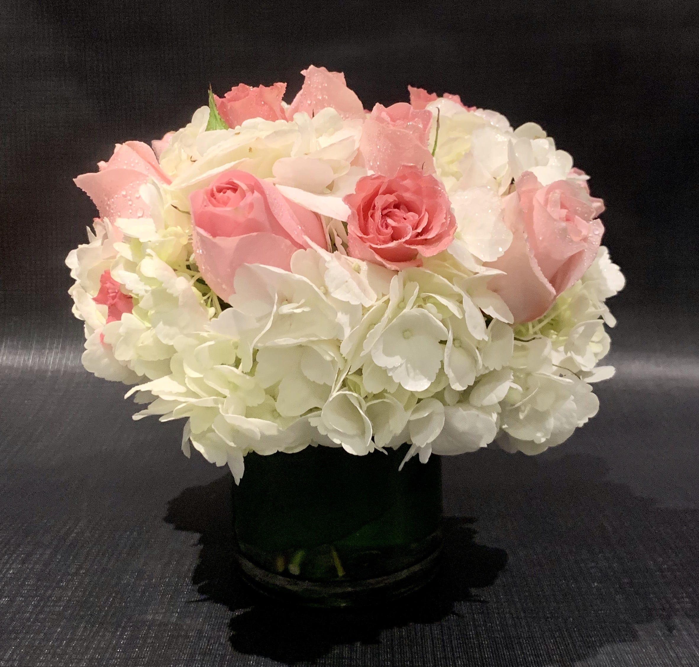 Custom Arrangement of Hydrangea &amp; roses - Custom Arrangement of Hydrangea &amp; roses in clear glass cylinder with leaf wrap.