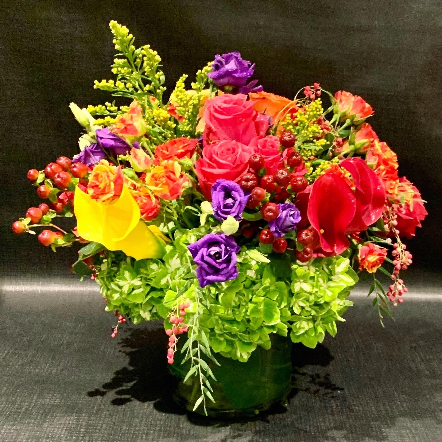 Custom arrangement of hydrangea, roses, lisianthus &amp; calla lilies - Custom arrangement of hydrangea, roses, lisianthus &amp; calla lilies in clear glass cylinder with leaf wrap.