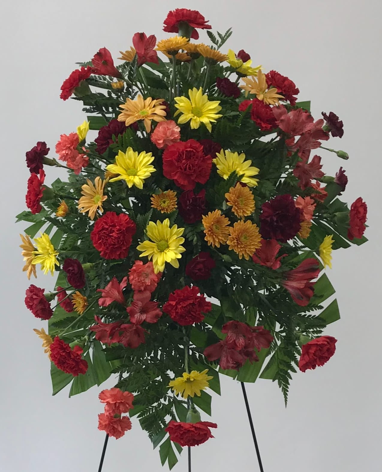 Thoughts of you. - This standing spray features red carnations with daisies, alstroemeria, and chrysanthemums. N249-2B