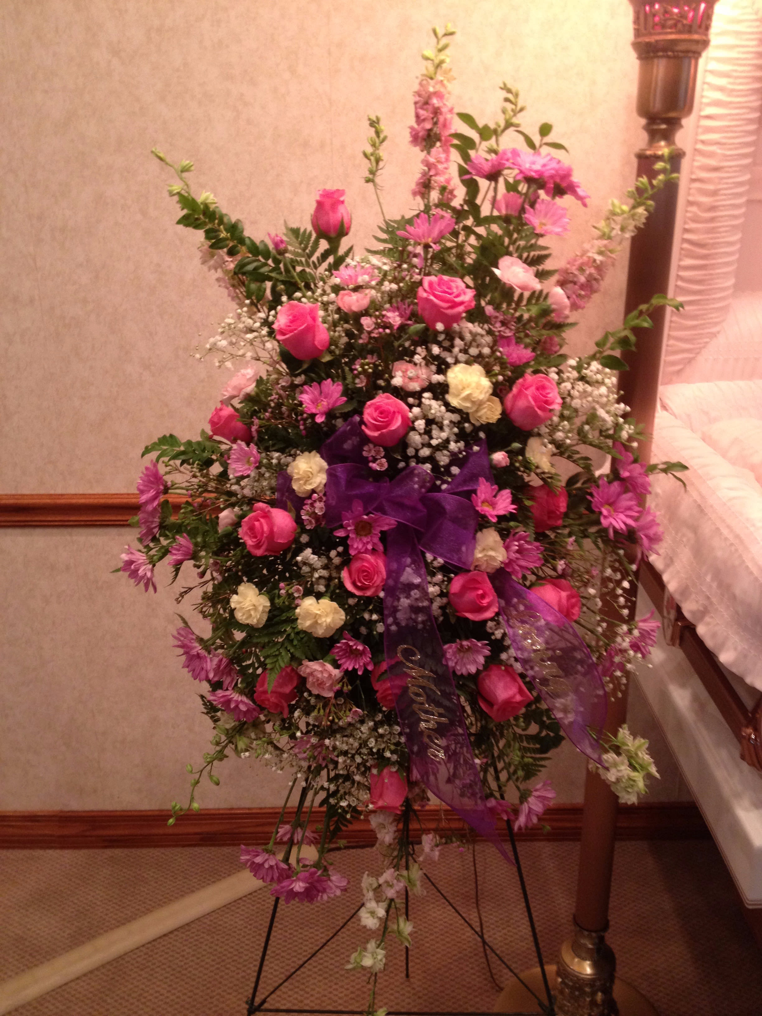  Touching Tribute Spray - Express admiration for her beauty and spirit with a striking tribute certain to evoke many cherished remembrances.  Gorgeous flowers such as pink roses, larkspur, daisies, mini-carnations and  baby's breath make up this thoughtful tribute.      Orientation: One-Sided 