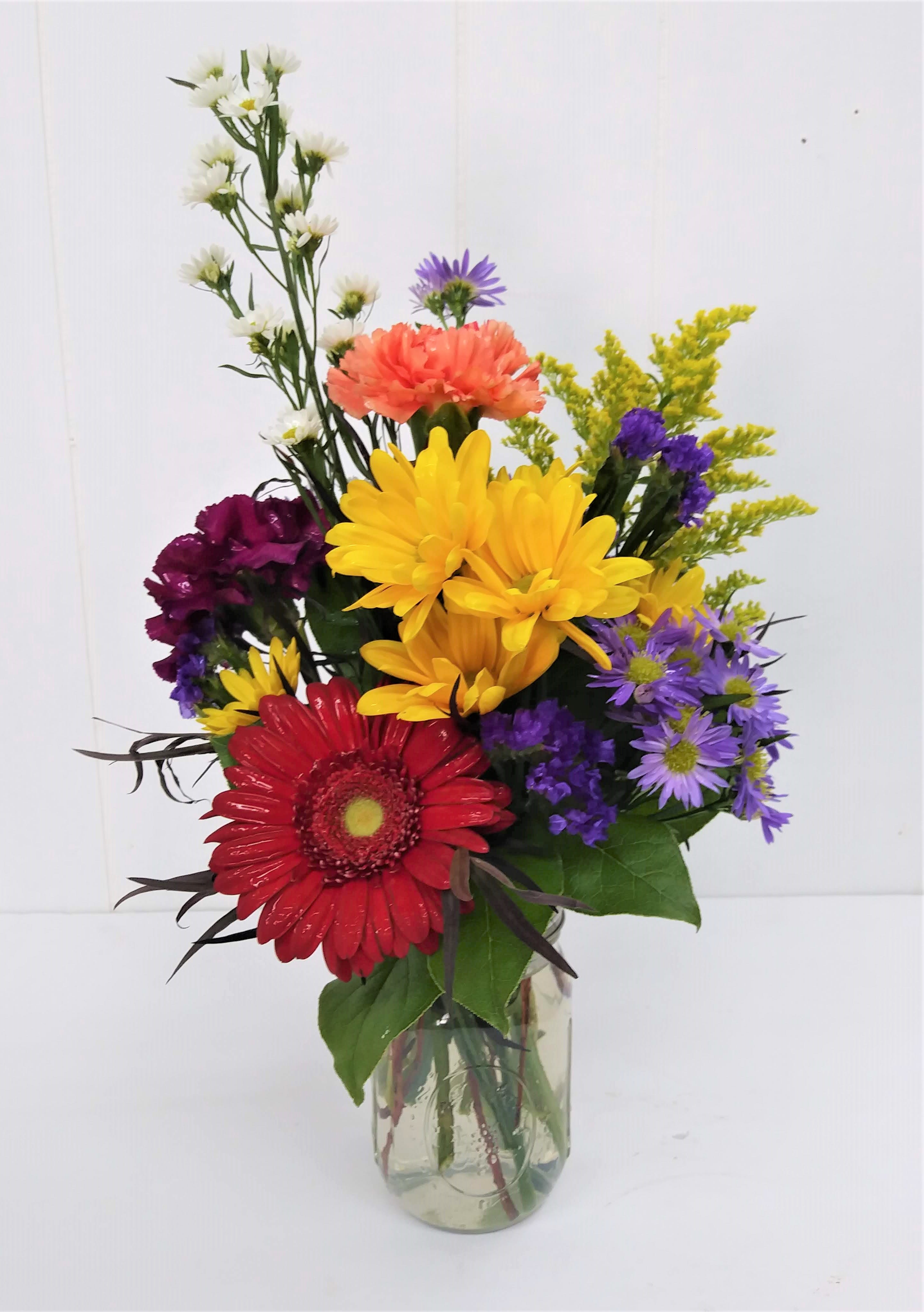 Marvelous Mason Jar - A lovely mixture of colorful summer flowers to celebrate any occasion or just make someone's day special. Carnations, gerbera daisy, white monte casino, purple monte casino, purple status and yellow daisies and solidago.