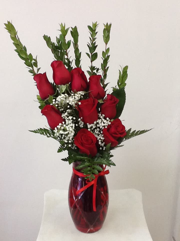 Flamingos Flowe's - Simply Yours Flamingos Flowe's - Simply Yours - Red roses to make a lasting impression. Gorgeous red roses are simply accented with a variety of fresh greens and perfectly situated in a classic clear glass vase to create a flower bouquet that conveys your heart's deepest desires for love and romance. Arrangement Approximately 15"H x 12"W.