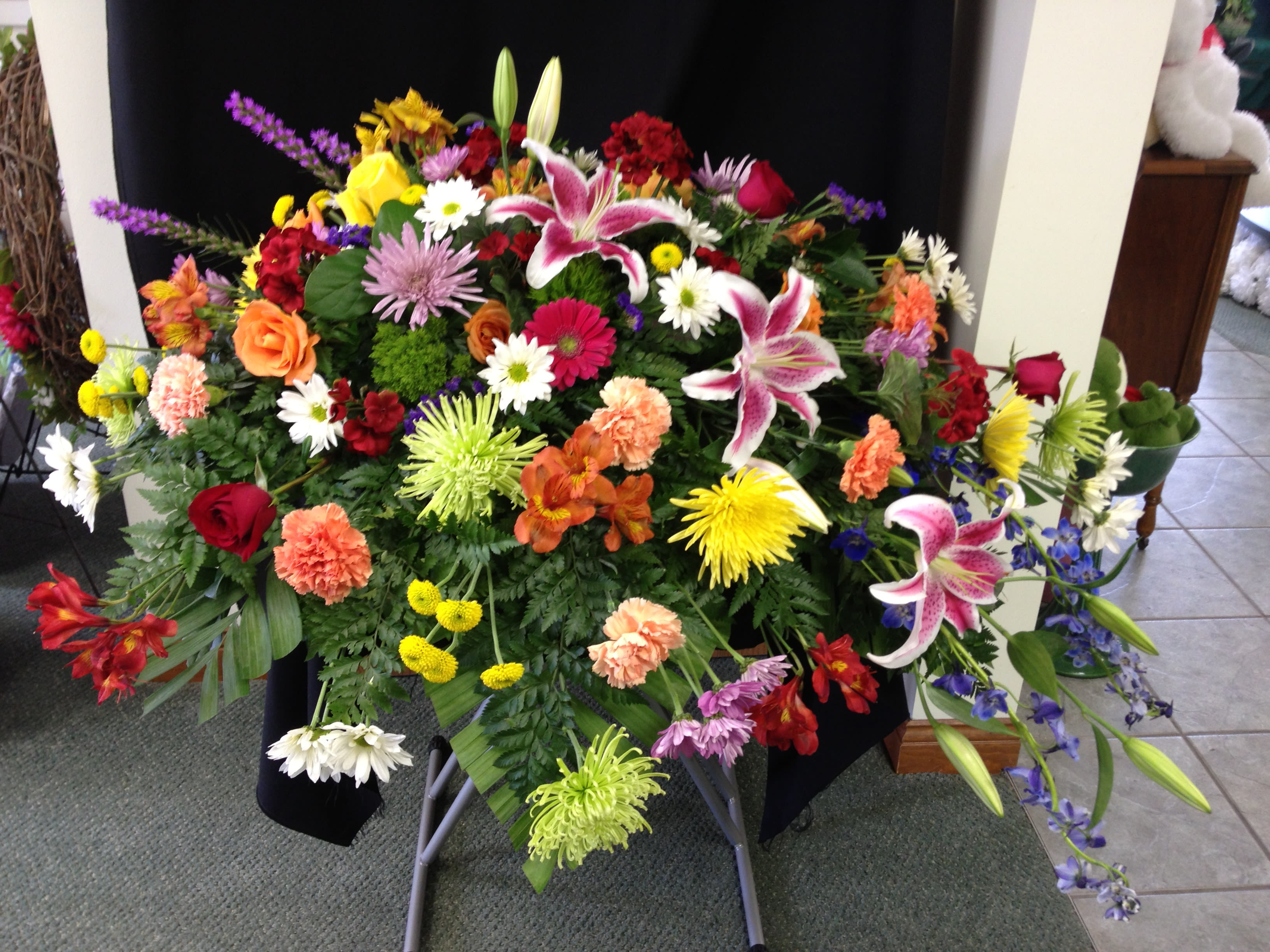 Mixed Spring Casket Spray - A mix of our most breathtaking spring flowers make this spray a beautiful tribute to your loved one. Flowers will vary seasonally and due to availability.