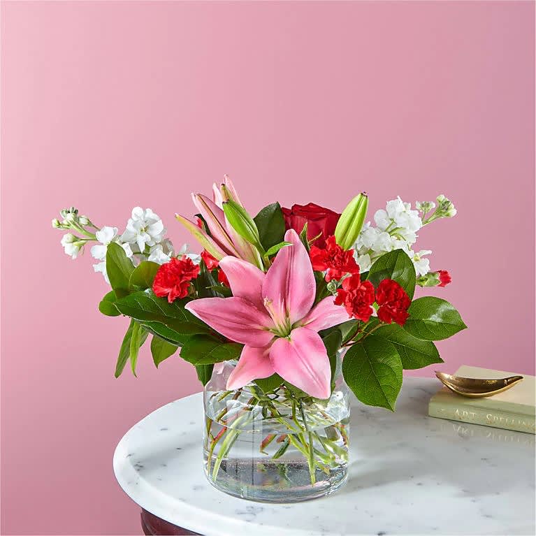 The Starstruck Bouquet - With an abundant blend of roses, carnations, and LA Hybrid lilies in a cinched glass vase, this captivating arrangement is sure to make them feel like they belong on the red carpet.