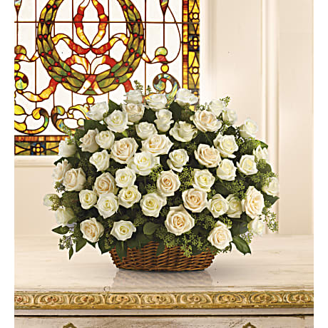 Bountiful Rose Basket - A beautiful bountiful basket of luminous white roses that feels so fresh natural and welcomed in a home or at a service. White and cr?me roses with fragrant seeded eucalyptus beautifully presented in a large basket.