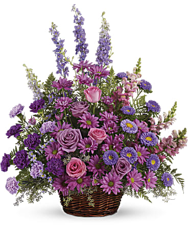 Gracious Lavender Basket - Soothing lavender respectful purple and compassionate pinks are combined beautifully in this basket overflowing with pretty flowers sincerity and sympathy. A lovely way to share your thoughts and pay tribute to someone special. A profusion of purple pink and lavender blooms such as roses carnations larkspur matsumoto and monte cassino asters and much more are delivered in a round wicker basket.