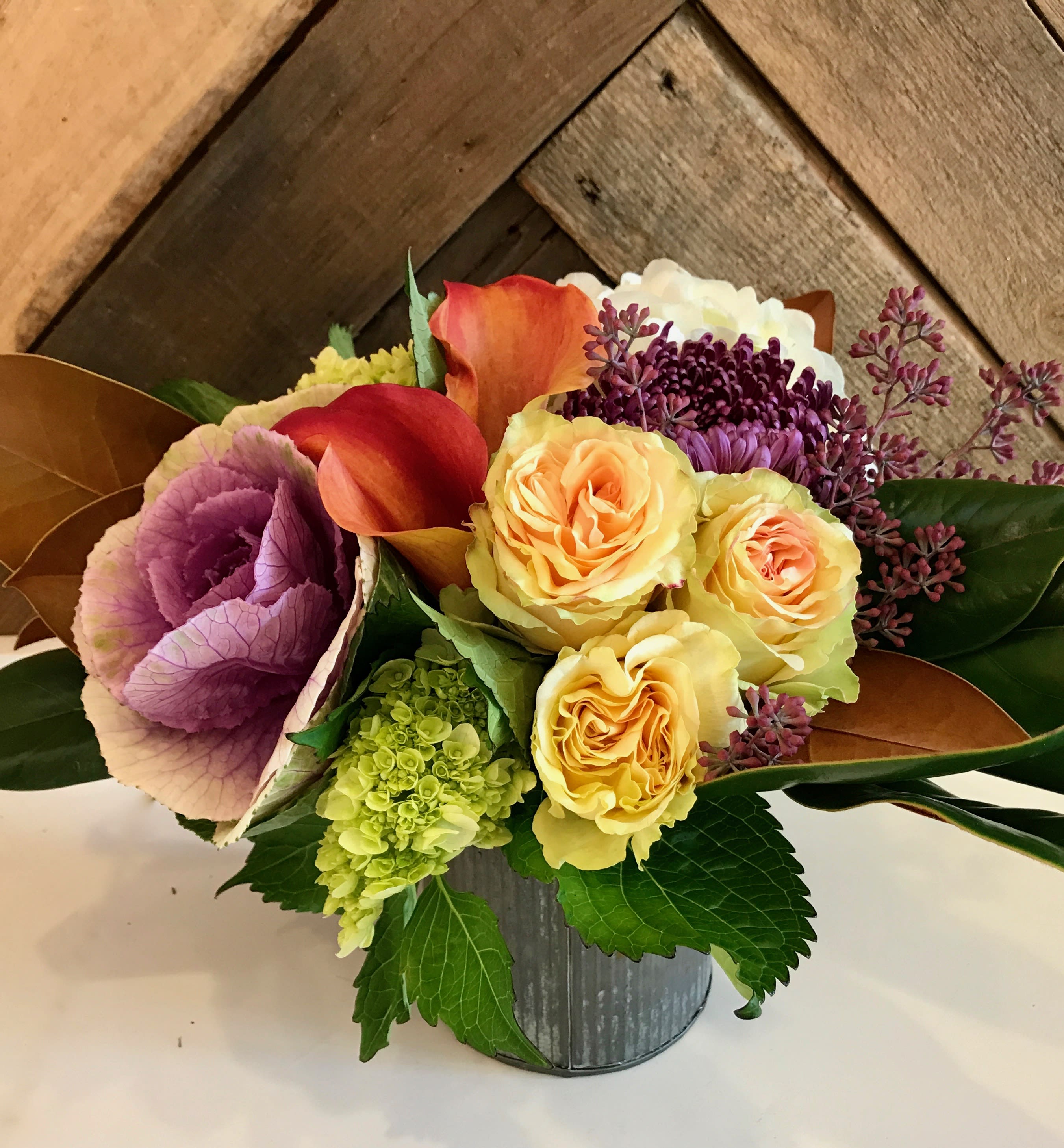 Designer's Choice Seasonal Jewel tone (Fall) - Our Designer's Choice Seasonal Jewel tone arrangements have high levels of colour saturation which makes them dynamic and eye-catching. We hand select our flowers and natural elements with a focus on American Grown flowers. This arrangement features blooms in brighter colors and is accented with seasonal greens designed in a complementing ceramic or metal vase. This arrangement is perfect as a birthday gift or as a festive centerpiece for any celebration.