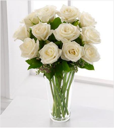 White Rose Simplicity - A dozen long stem white roses delivered in a clear glass vase with minimal greens and filler flowers to highlight these beautiful white roses.