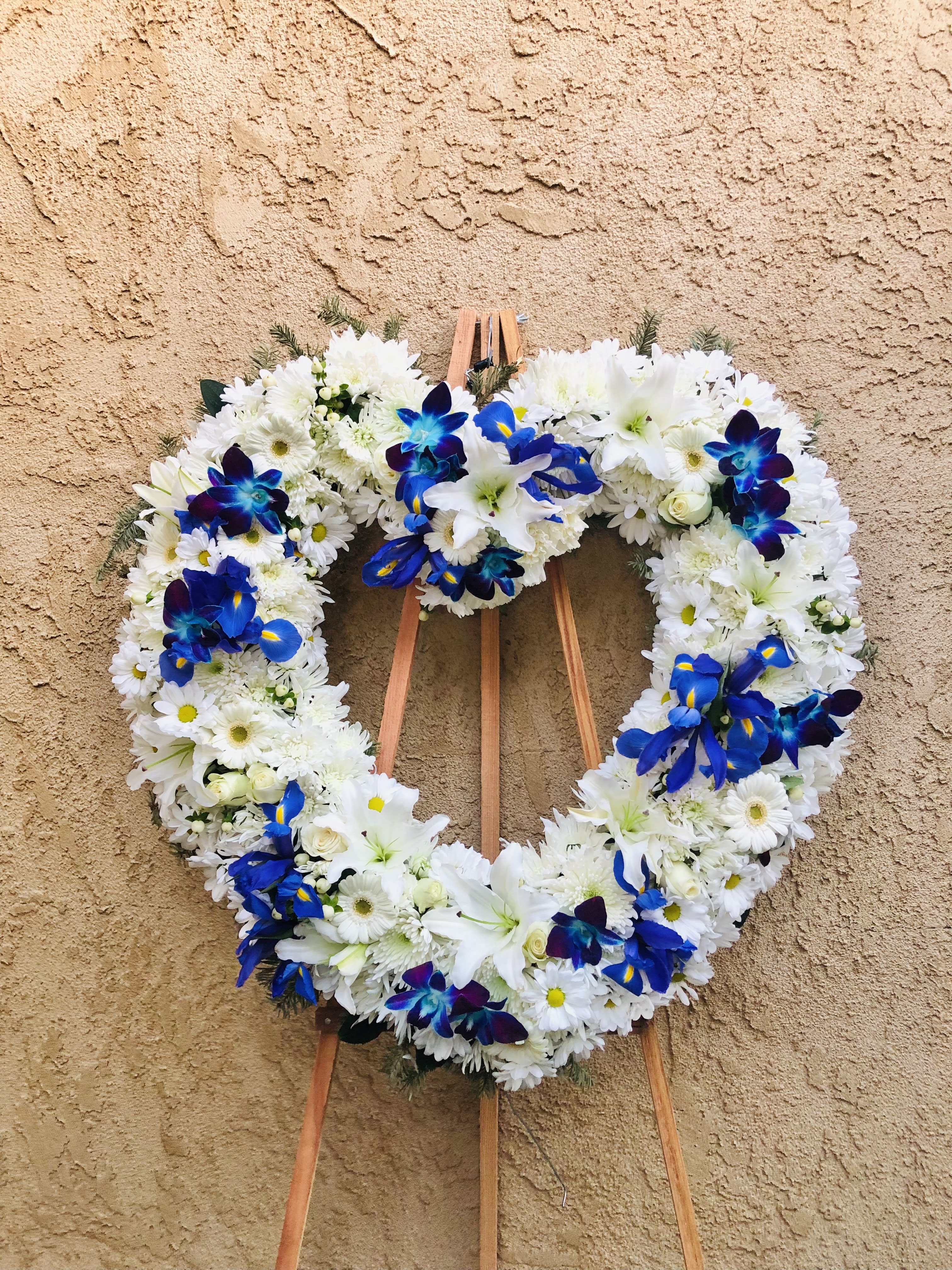 My Sky - Beautiful funeral spray featuring iris, daisies, mums, lilies, and green accents.