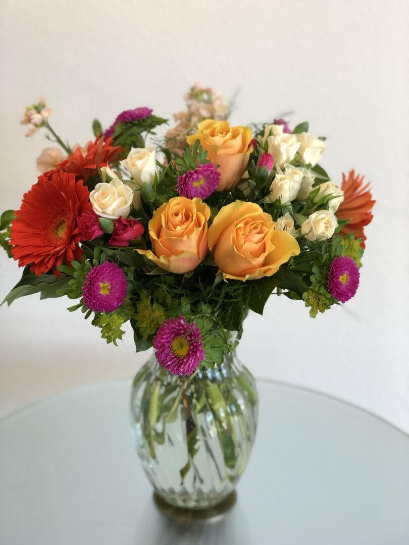 SWEET SWEET - "How sweet it will be when this dazzling arrangement arrives at someone’s door. Very vibrant. Very vivacious. And very, very pretty. Light orange roses, orange spray roses, and matsumoto asters, hot pink miniature carnations and more are delivered in a lovely glass vase. Be sweet and send this one today! Orientation: All-Around All prices in USD ($)"