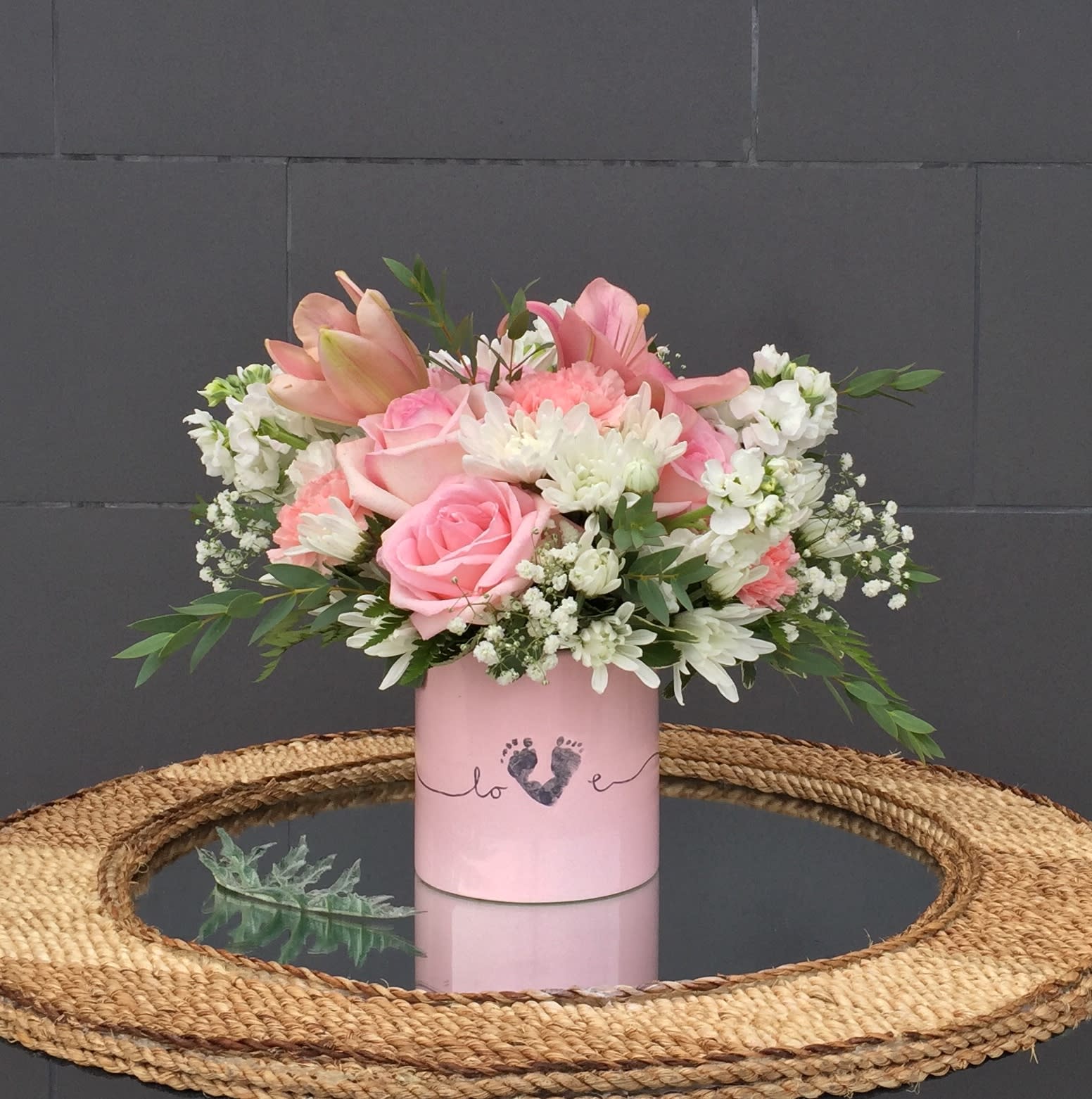 Beautiful Baby Girl - Sweet design including lily, rose, pompon... and accents in a lovely pink vase is a good gift to welcome a new baby girl. STANDARD: FIRST PHOTO DELUXE: SECOND PHOTO