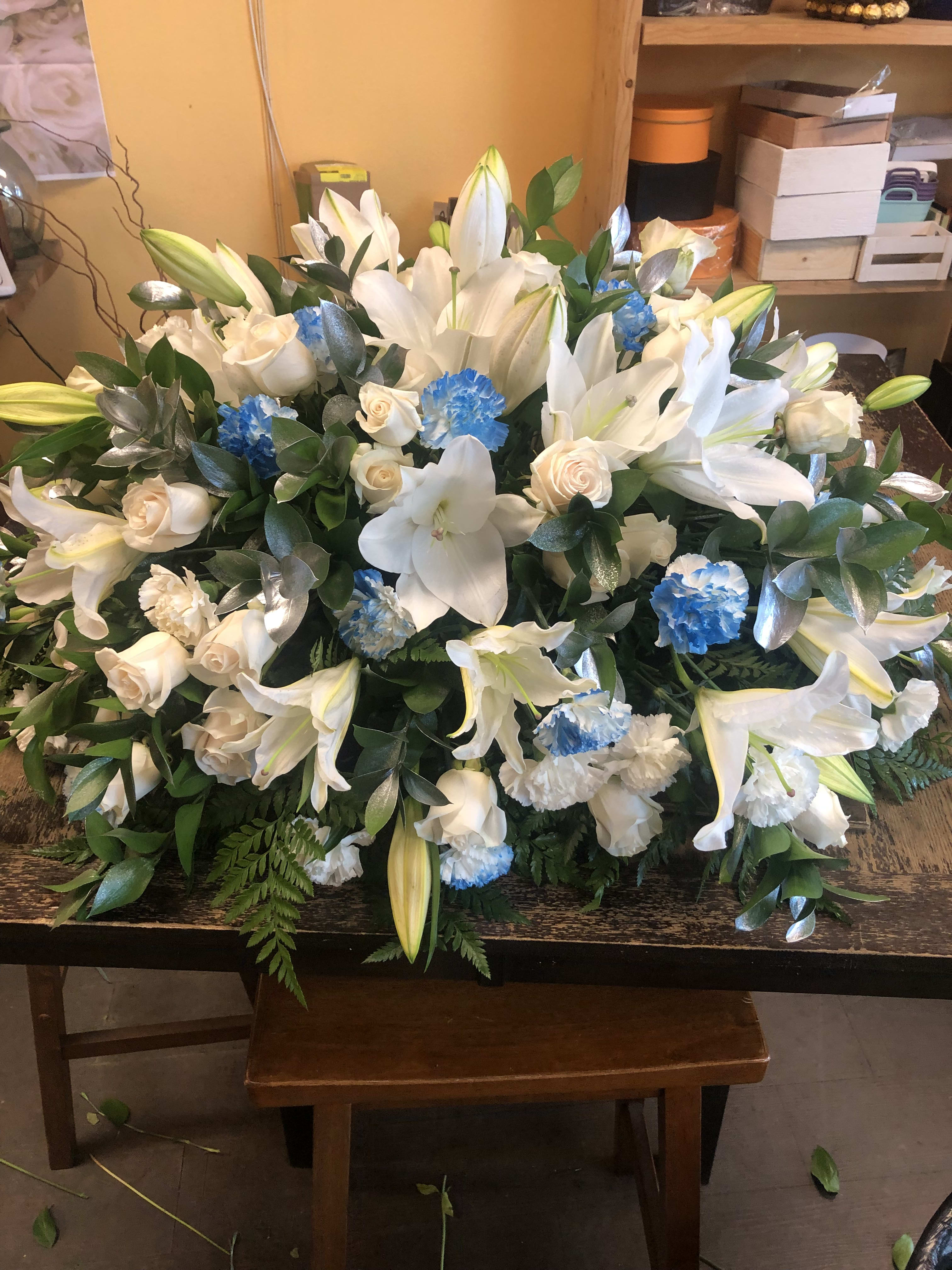 White and Blue Casket Spray White and Blue Casket Spray - 36 Off White Roses, white Lilies and white Carnations and (Carnations Spray painted in blue) and silver painted ruscus leaves. It measures 36 inches long. See video of this casket spray on my instagram account Aleeaflowers. NOTE if you place this order (three days or less days of the service funeral time) the lilies will be closed. We need at least a week to make sure lilies are open. Thanks any questions please call us 9513791222