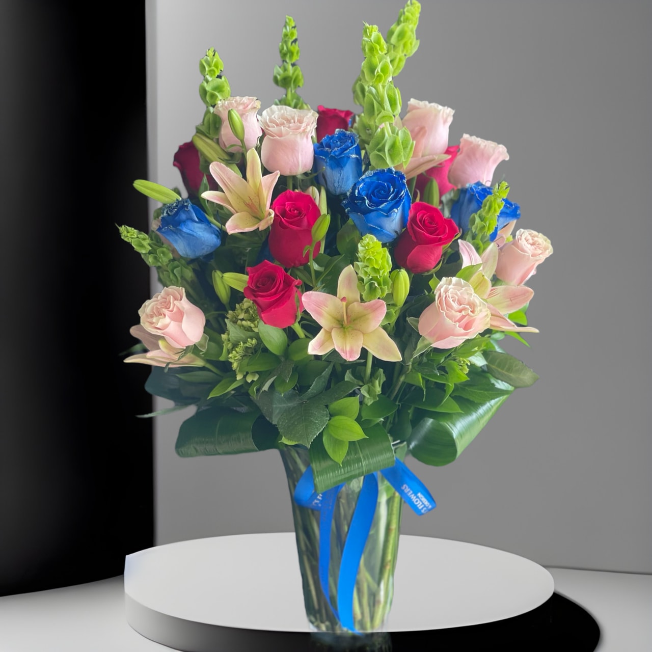 Sugar Sugar - This is the most whimsical way to sweeten somebody's day. This beautiful boho arrangement with peach and hot roses, blue roses, lilies and bells of ireland in a tall vase that will elevate any space. Perfect for Women's Day, Mother's Day, or any birthday.