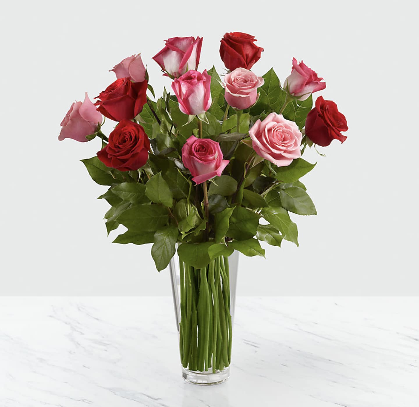The True Romance Rose Bouquet - The True Romance Rose Bouquet is the perfect expression of love and passion. A bright burst of color, this bouquet combines red, pink and fuchsia roses, accented with beautiful greens and seated in a clear glass vase, to create a truly romantic representation of your love.