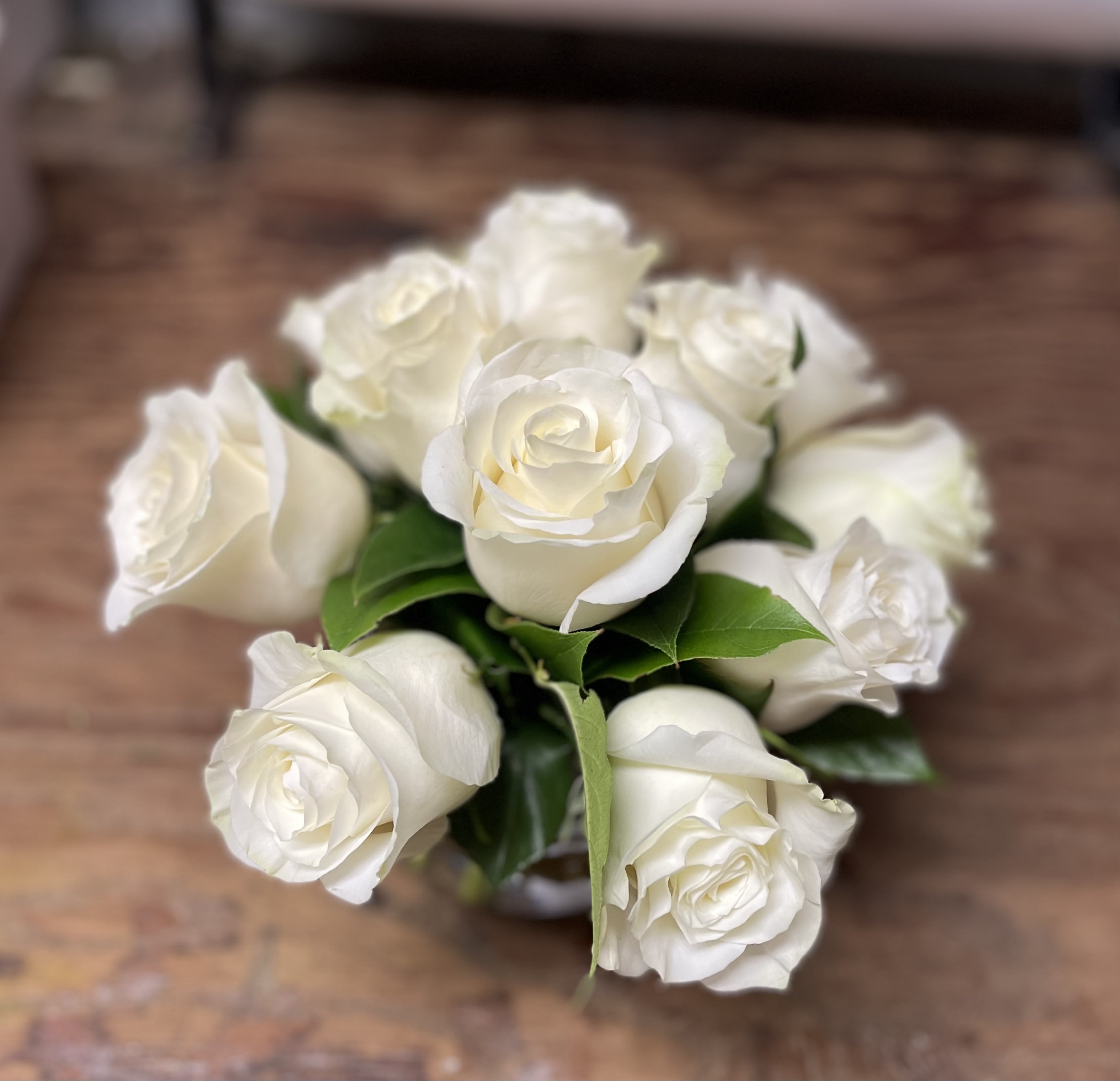 White Blossom White Blossom - A Dozen white roses in a short vase.