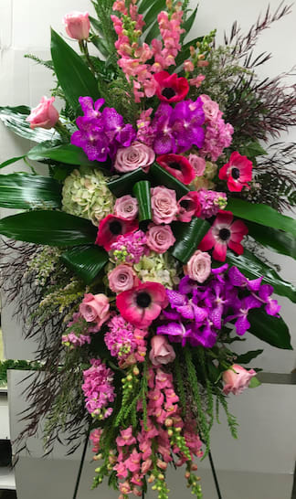On To Paradise On To Paradise - Roses, orchids, snapdragons, poppy and other beautiful accents to make this spray stand out.