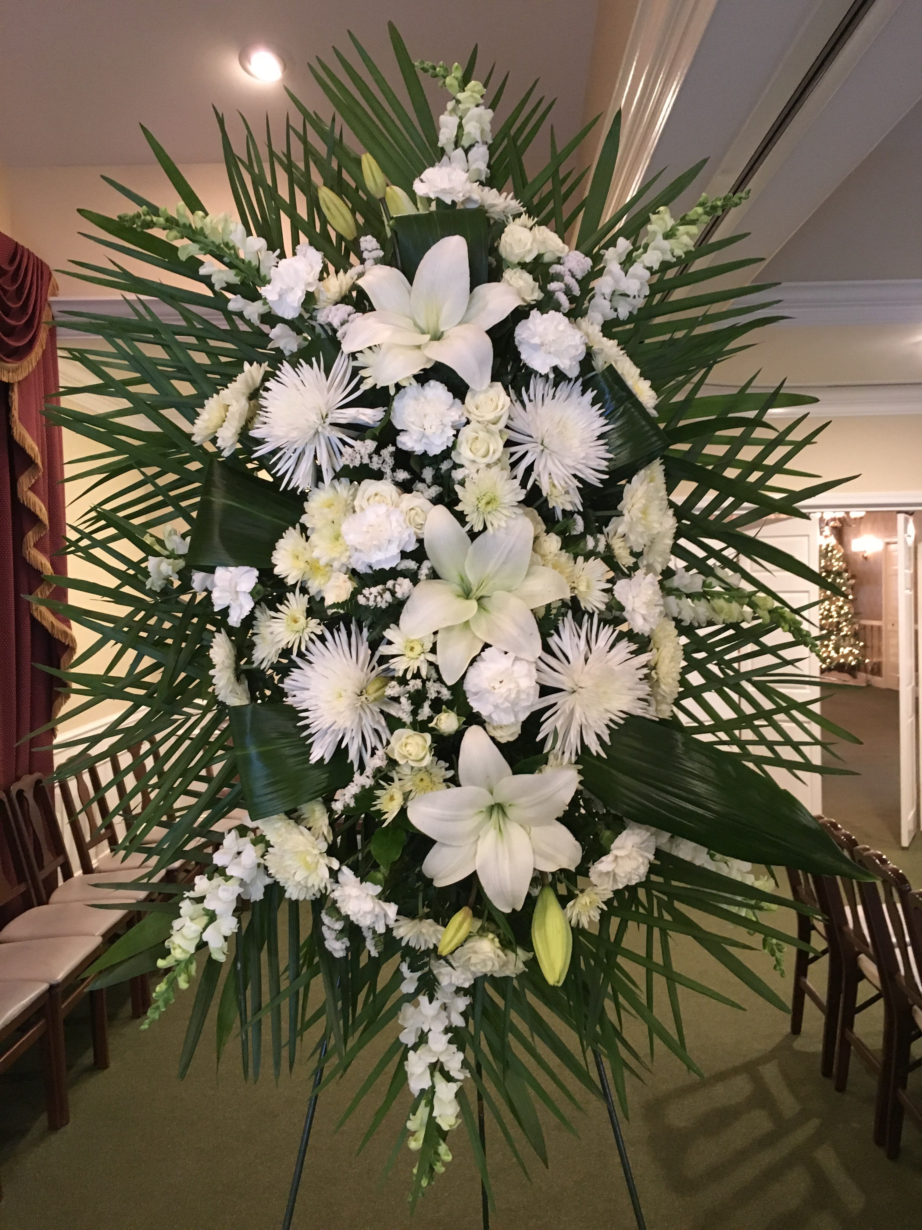 Simple Elegance Simple Elegance - Simple, yet outstandingly beautiful, this clean spray of heavenly white lilies, starburst mums, roses and more is sure to gain a few compliments while expressing your deepest sympathies.