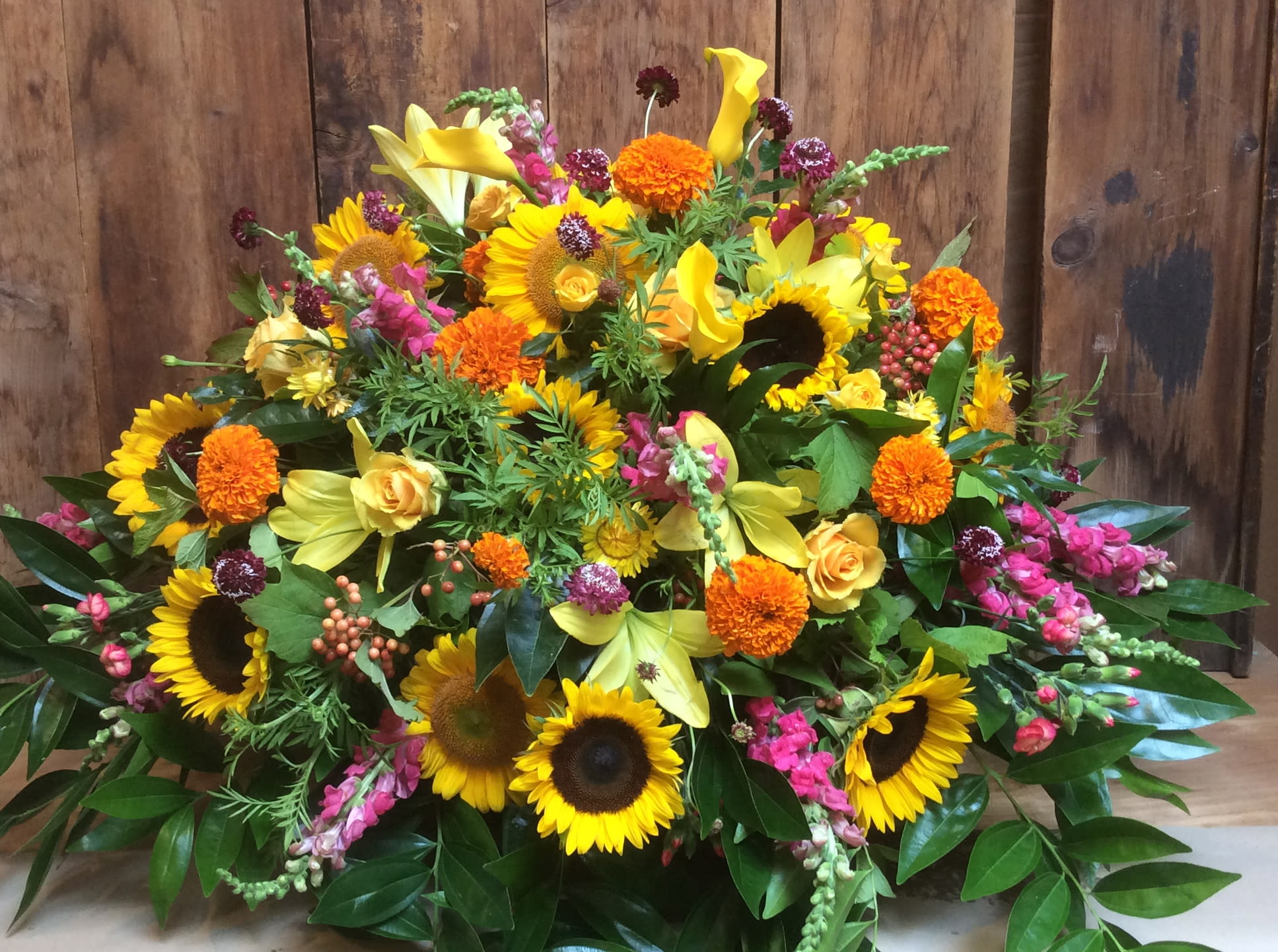 Yellow, Orange &amp; Pink  Casket Blanket - - Send an elegant expression of your love and a touching tribute to a loved one with this bright casket blanket. An assortment of seasonal vibrant flowers  are arranged with lush greenery to make the perfect tribute for your loved one.