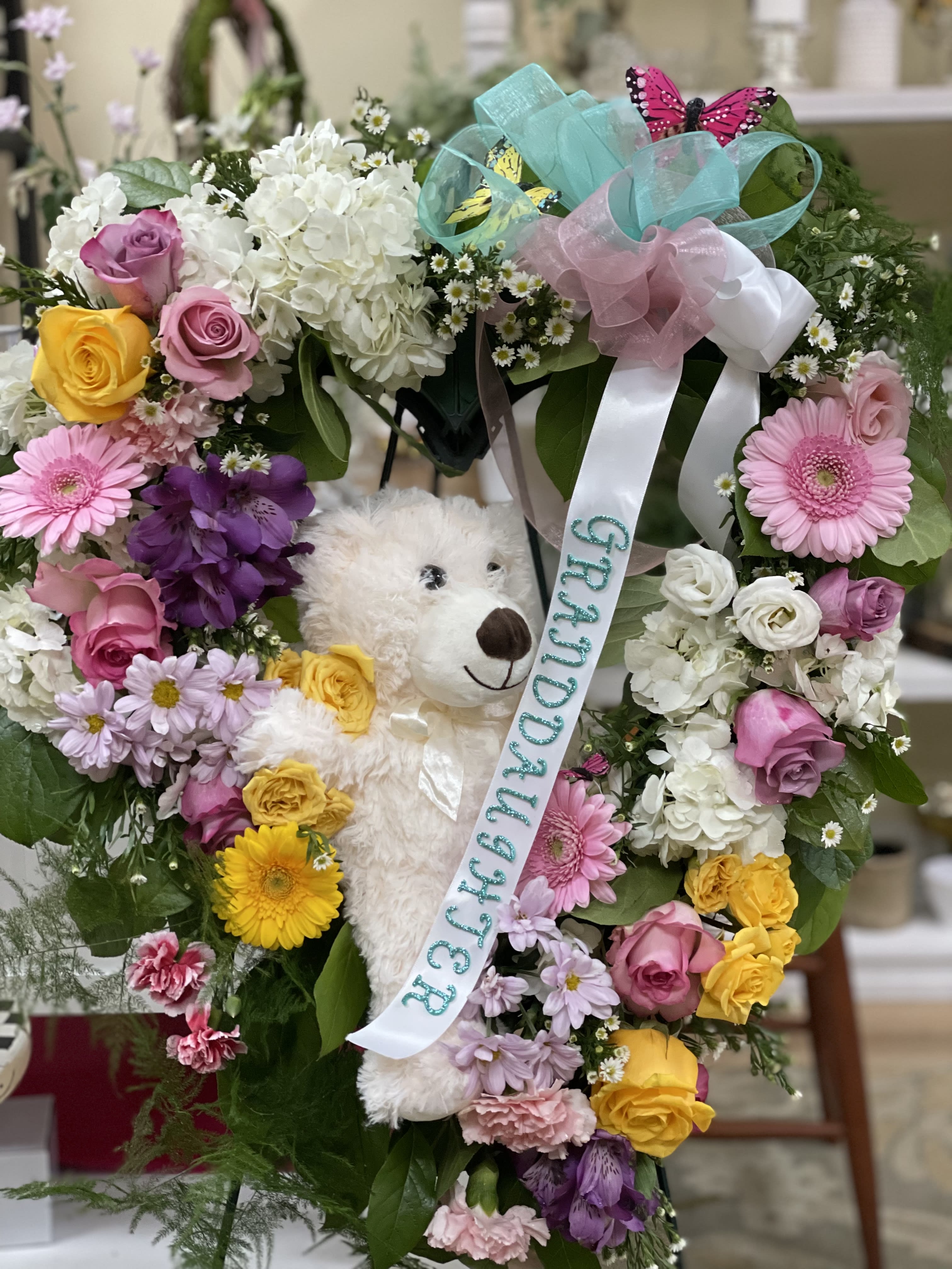 Colorful Wreath - We will design with a personal touch for your loved one, we use colorful flowers and you can specify if you want a ribbon sash on it or not. Teddy bear is an option.