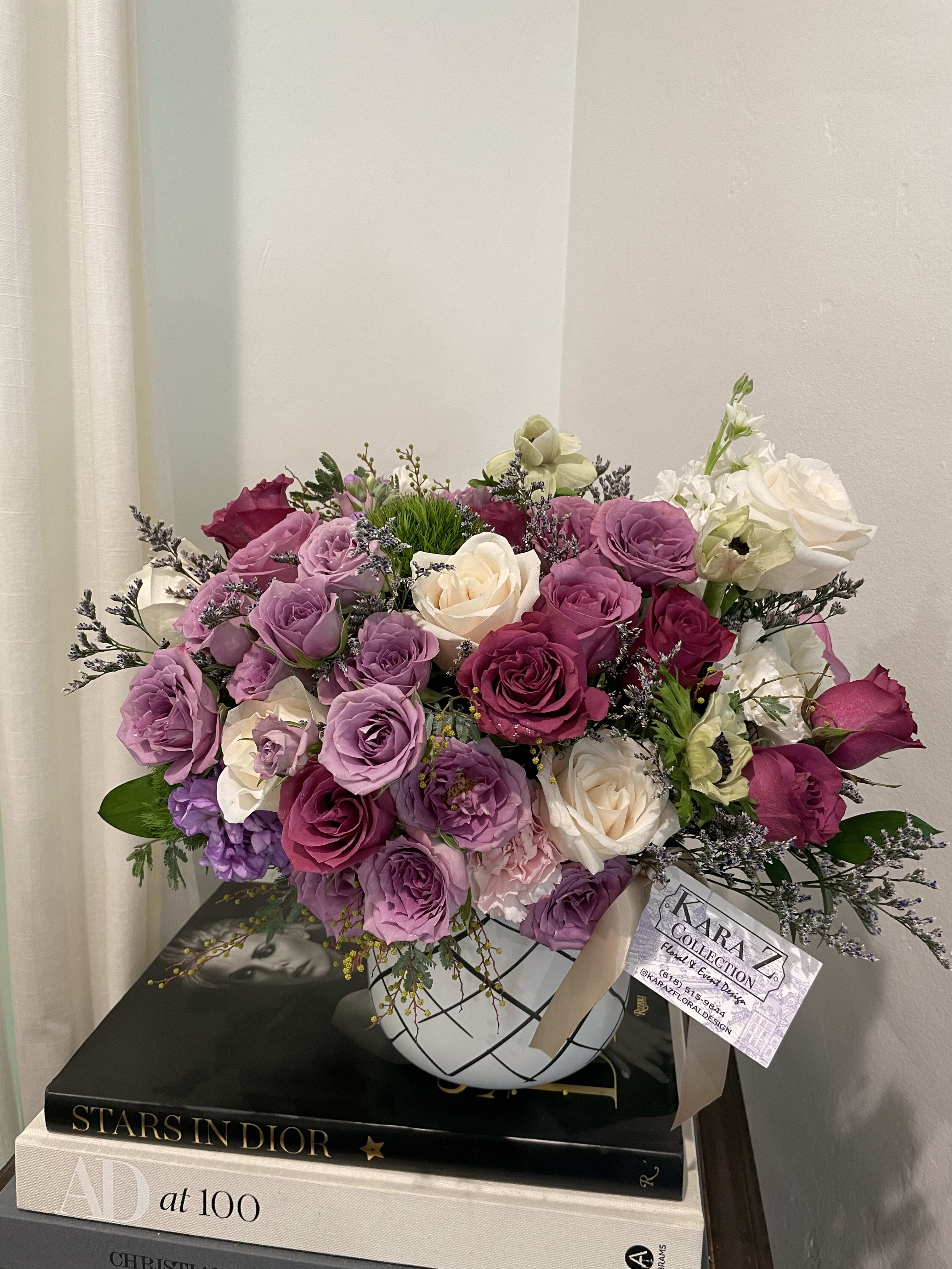 Delicate Lavender  - Beautiful Ivory and lavender roses, lush greens arranged with other premium and seasonal florals to create a one of a kind arrangement. Ideal for any occasion and sure to make a statement. 
