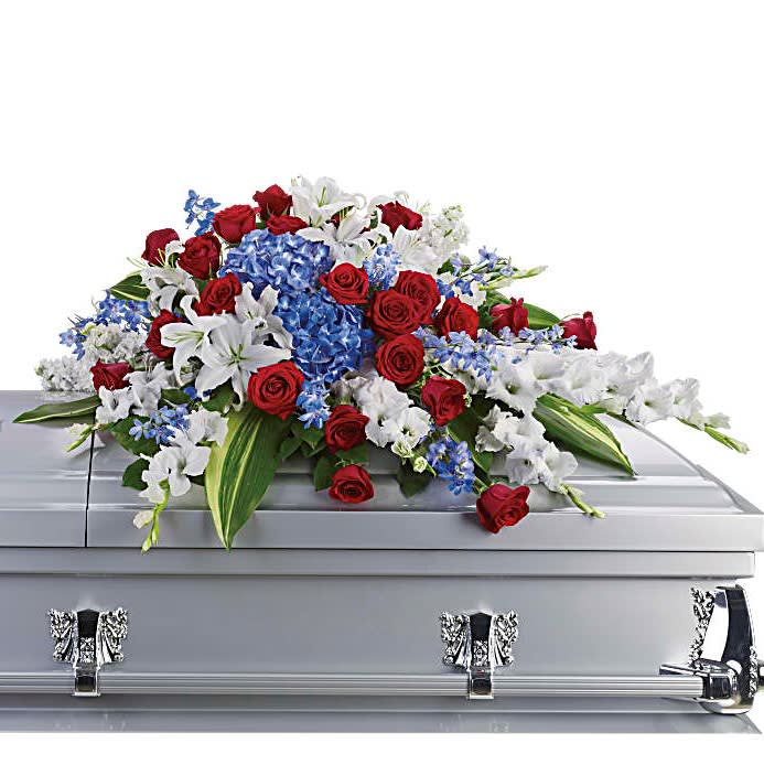 Honor and Glory Casket Spray - For a military or private funeral, this classic casket spray is a proud and patriotic way to pay lasting tribute to a loved one's esteemed memory, life of service and dedication to freedom.  Bold flowers such as blue hydrangea and delphinium, classic red roses, and white oriental lilies and gladioli form an all-American display honoring the deceased and their love of country.