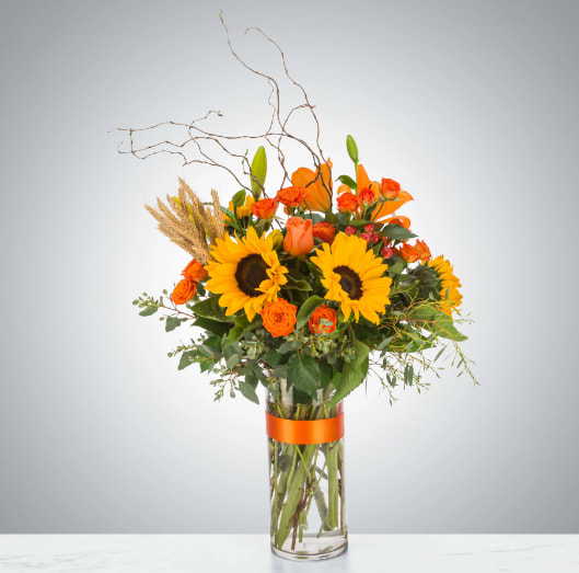 Hayride by BloomNation™ Hayride by BloomNation™ - The ultimate fall flower mix featuring sunflowers and a variety of orange flowers with eucalyptus and curly willow accents. Send this arrangement for Halloween, Thanksgiving, or to celebrate the season! Approximate Dimensions: 18"D x 29"H