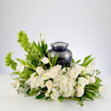 Serenity by BloomNation™ - An all white tribute, this all white funeral urn is pure and tranquil. Featuring a variety of white flowers, this urn arrangement compliments the beauty of life. 