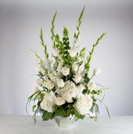 Sweet Comfort by BloomNation™ Sweet Comfort by BloomNation™ - An all white tribute, this funeral basket is pure and tranquil. Featuring a variety of white flowers and greenery, this design reaches for the sky and evokes a feeling of peace upward and outward.