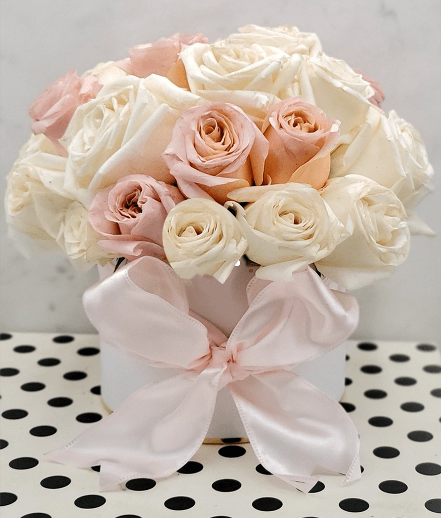 Flamingos and Polka Dots - This delightful arrangement is filled with a variety of our handpicked premium garden roses, and premium spray roses in the largest of blooms, presented in a white hat box with adorable gold polka dots and wrapped up in a giant fluffy satin blush bow.