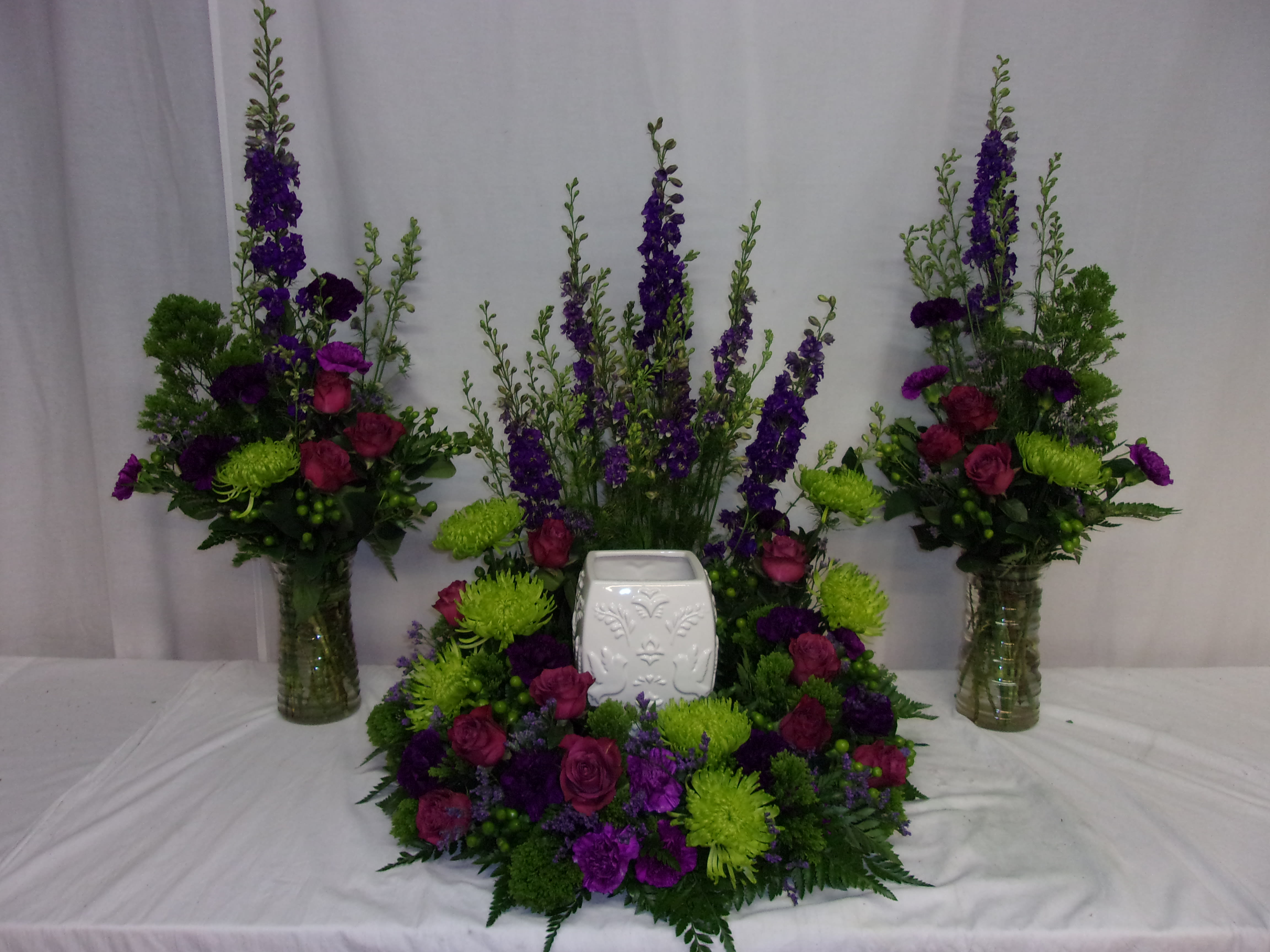 Eternal Remembrance Cremation Setting - This ensemble is a beautiful expression of love and caring at a time of sadness. The combination of flowers in the floral trio including lavender, purple, fuchsia and green will complement almost any urn, and make it a beautiful focal point during the service.