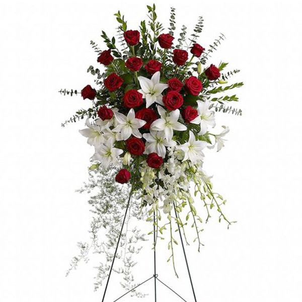 Feelings Sympathy Standing Arrangement  - Red is the color of love and this standing spray displays it with luxurious style. Red roses and palms come together with other red and greenery to create a beautiful salute. This arrangement can be delivered to any funeral home prior to the service. Including Forrest lawn memorial, San Fernando funeral Funeral home and more Funeral services in Los Angeles. 