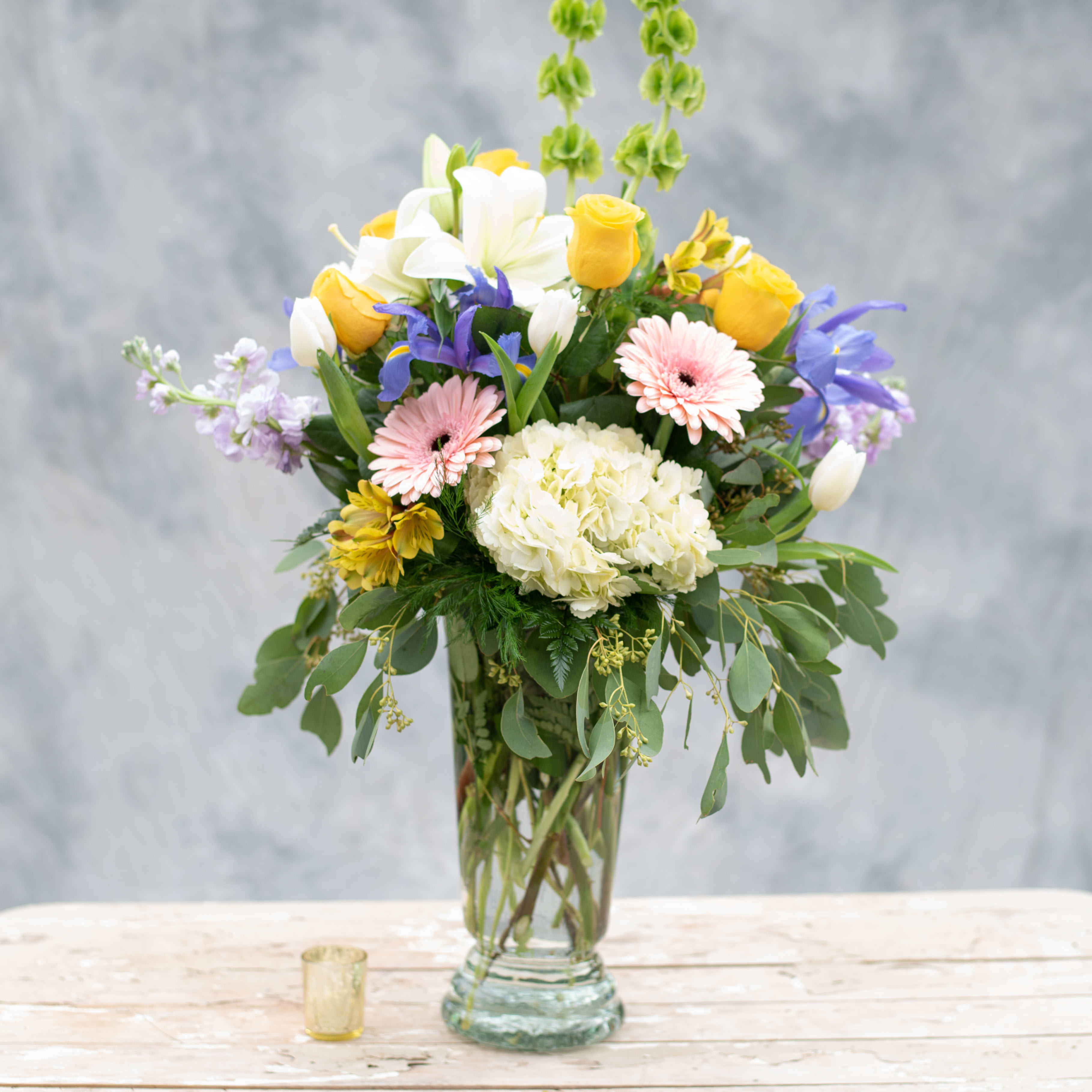 Garden Jewels - Make a statement by sending this elegant and soft arrangement, filled with &quot;Jewels&quot; from the best gardens, including, hydrangea, gerbera daisies, yellow and white roses, iris, bells of Ireland and so much more!