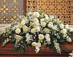 The ivory elegant casket spray The ivory elegant casket spray - A collection of white and ivory flowers such as roses snapdragon or larkspur carnations and baby breath. A lovely traditional style.