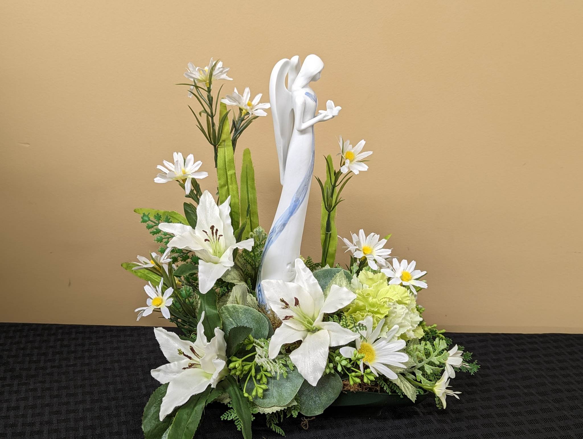 Angel of Comfort - This Angel of Comfort sits among fresh white lilies, white daisies, green hydrangea and an assortment of fresh greenery. 