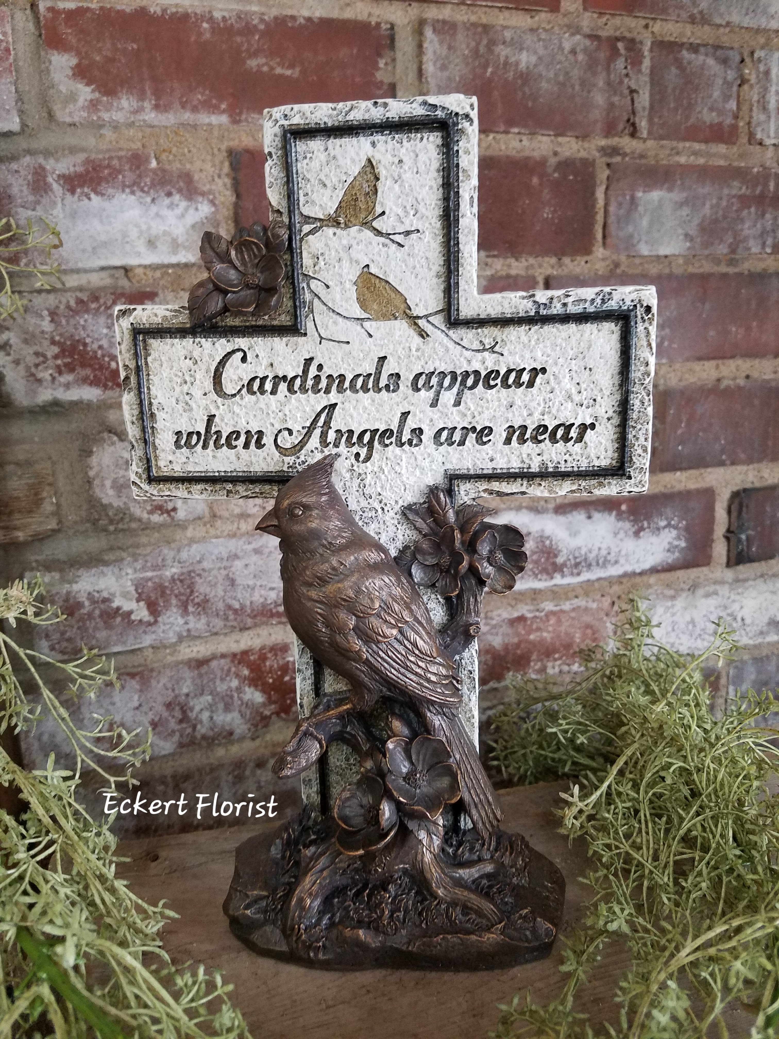 Eckert Florist's Cardinal Cross *LOCAL DELIVERY ONLY - This bronze colored cardinal bird with cross is a great keepsake memorial. Made from resin material and measuring approx. 11.75&quot; H x 7.25&quot; W. This gift can be added to a fresh arrangement or green plant. (See Deluxe or premium upgrades) *LOCAL DELIVERY ONLY 