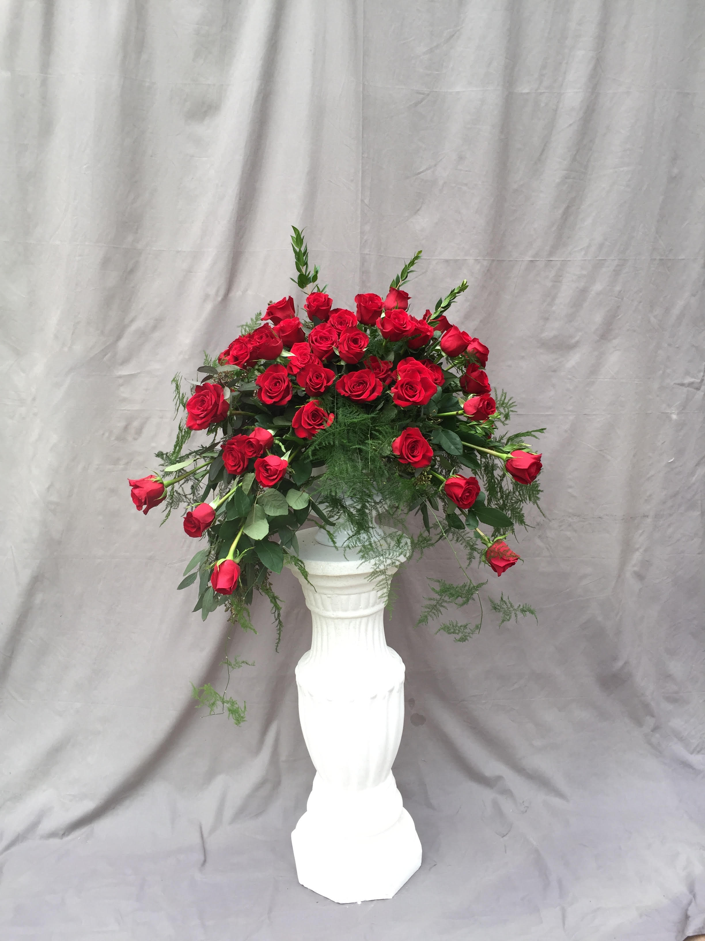 Red Rose Sympathy Urn - Our beautiful red freedom roses with lush greenery make a lovely tribute to your loved one.