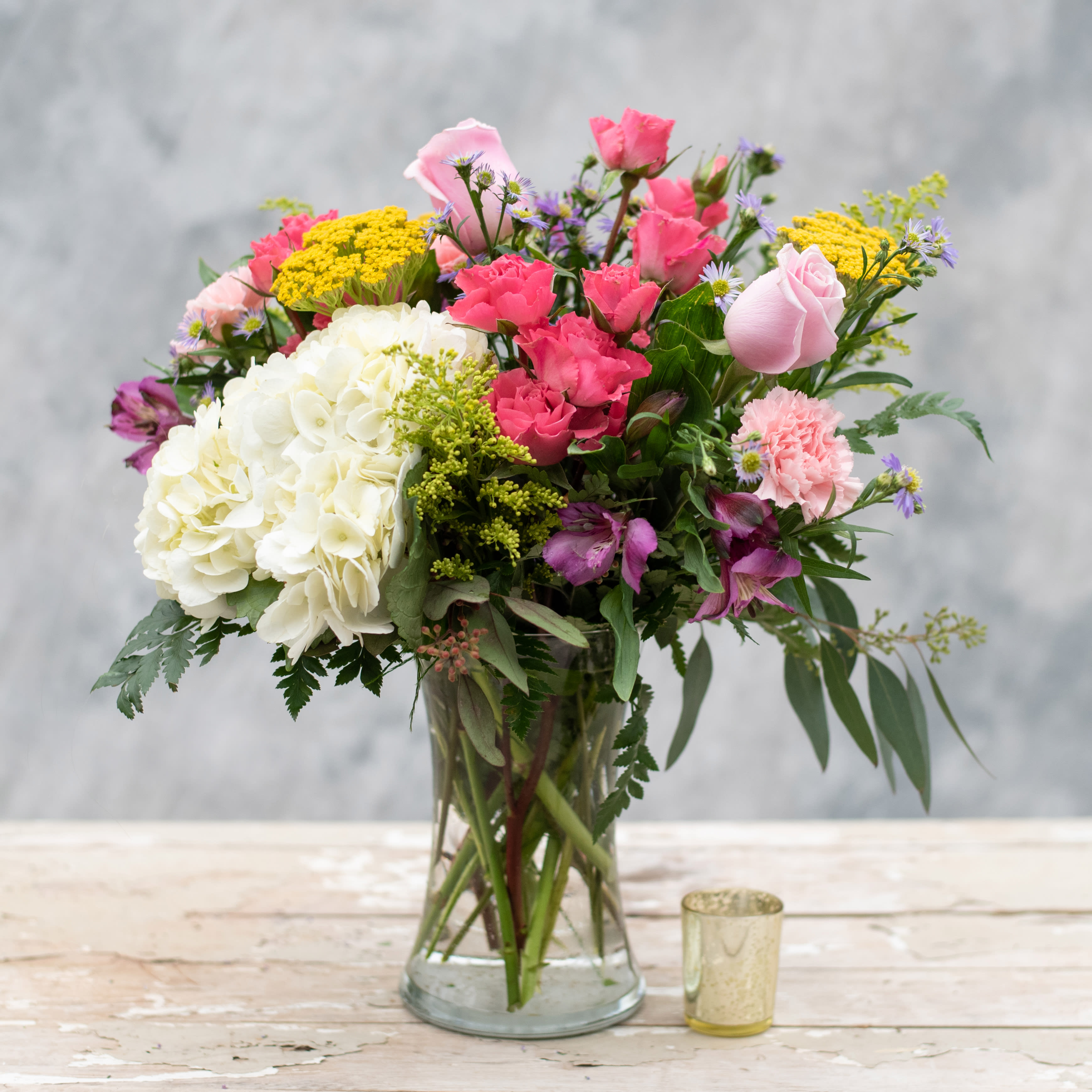 Sweet Garden - Time to bring your &quot;Sweet Garden&quot; inside with this 8&quot; clear gathering vase filled with the colors of spring, including pink spray roses, purple alstroemeria, pink carnations, white hydrangea, yarrow and more.  