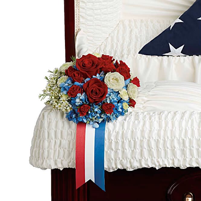 Honor and Glory Casket Insert - Adorn the casket with a proud display of patriotism. This breathtaking arrangement of blue hydrangea and rich red and white roses is a touching tribute to an honorable legacy.  Insert includes: Blue hydrangea, red roses, red spray roses, white spray roses, white button spray chrysanthemums, and white waxflower.